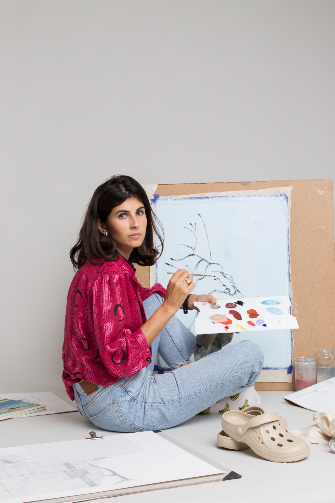 An artist painting on the studio floor