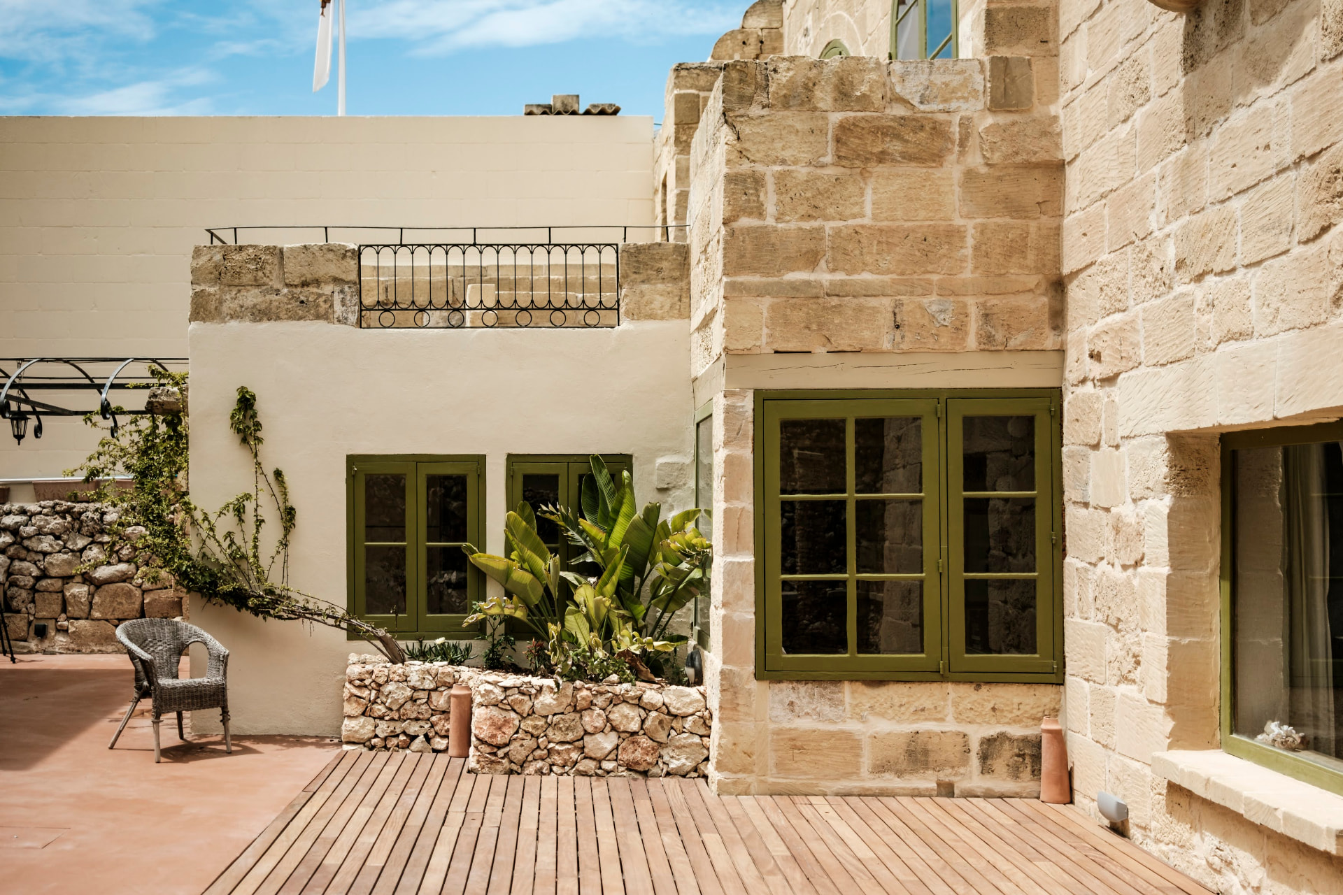 The sunlit stone courtyard at the house, and hands stitching a booklet